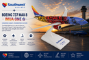 Southwest Airlines model airplane with colorful design on a stand, set against a sunset background.